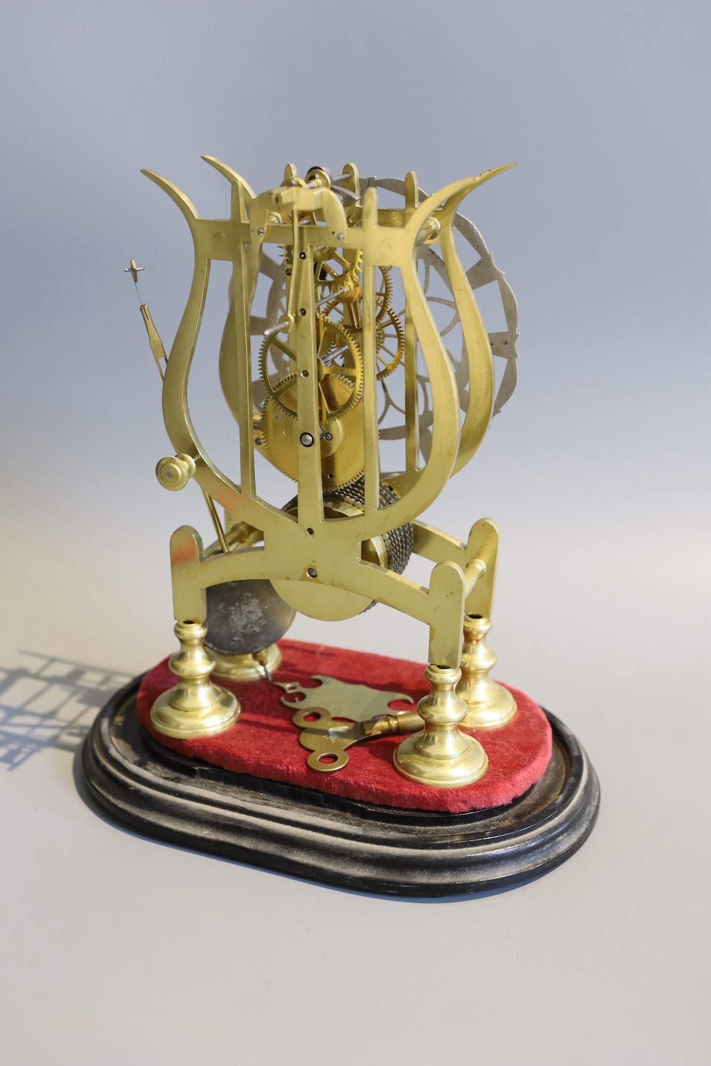 A 19th century brass skeleton mantel timepiece, under glass dome, with single fusee movement and pierced silvered chapter ring, height 24cm